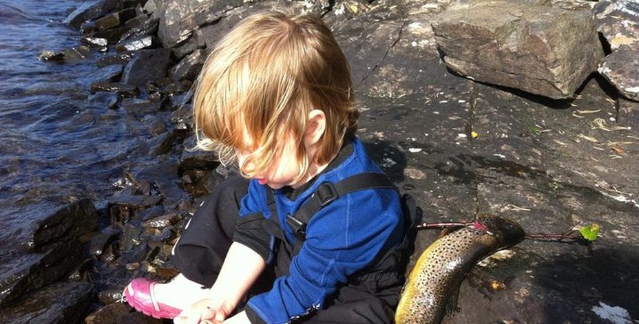 Bild på ett barn som rensar fisk